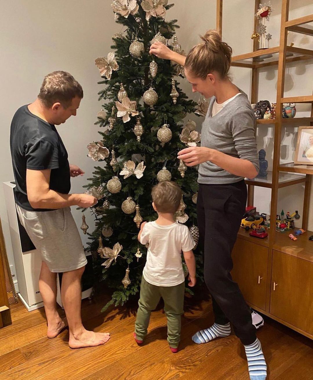 Катерина Осадча з родиною прикрашає новорічну ялинку.