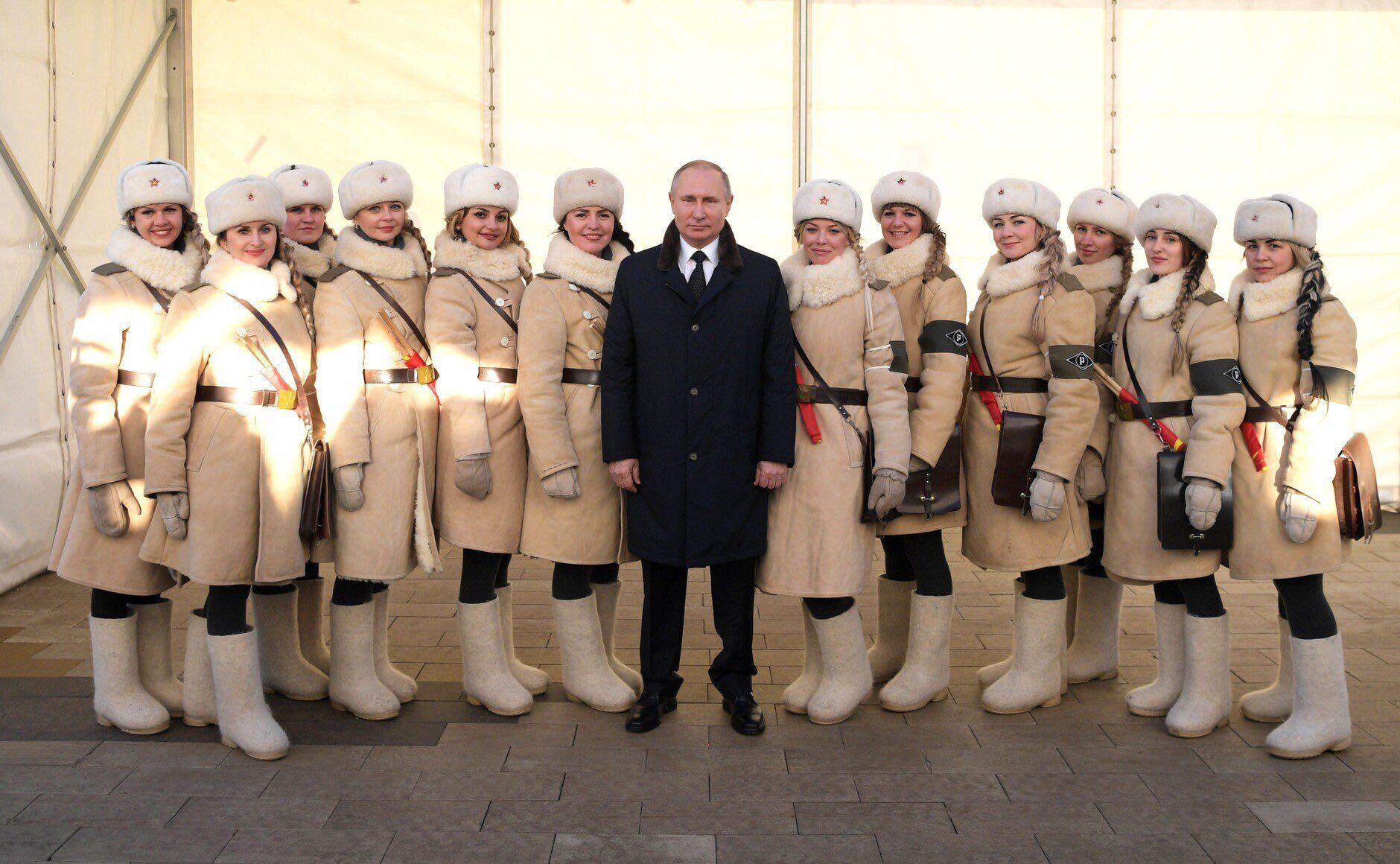 Володимир Путін і низькорослі жінки в формі радянських регулювальниць Військової автомобільної інспекції у Волгограді