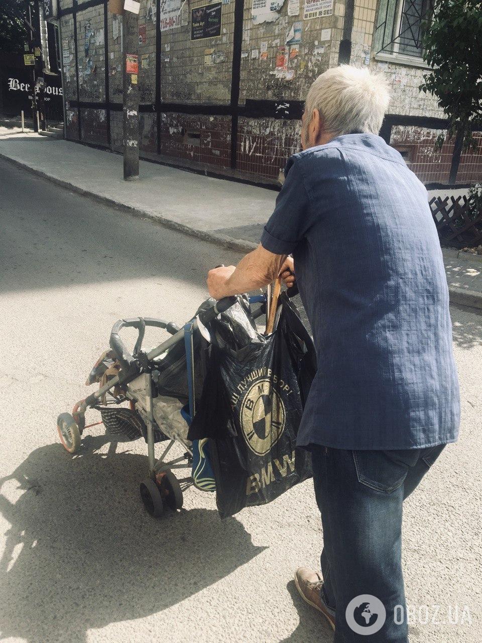 Пожилой мужчина собирает бутылки