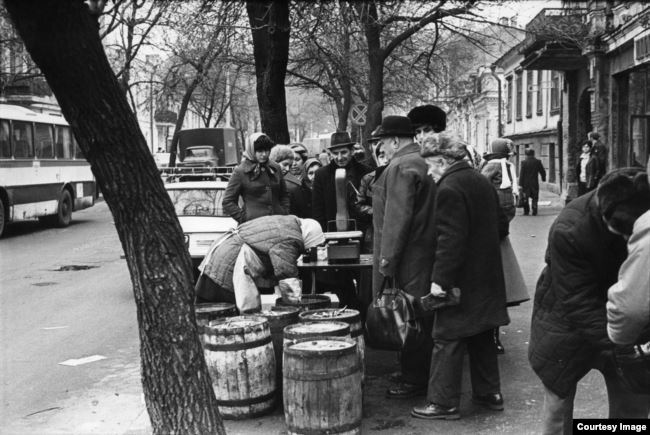Фотограф изображал моменты повседневной жизни позднего СССР, например, как эта очередь за селедкой на улице