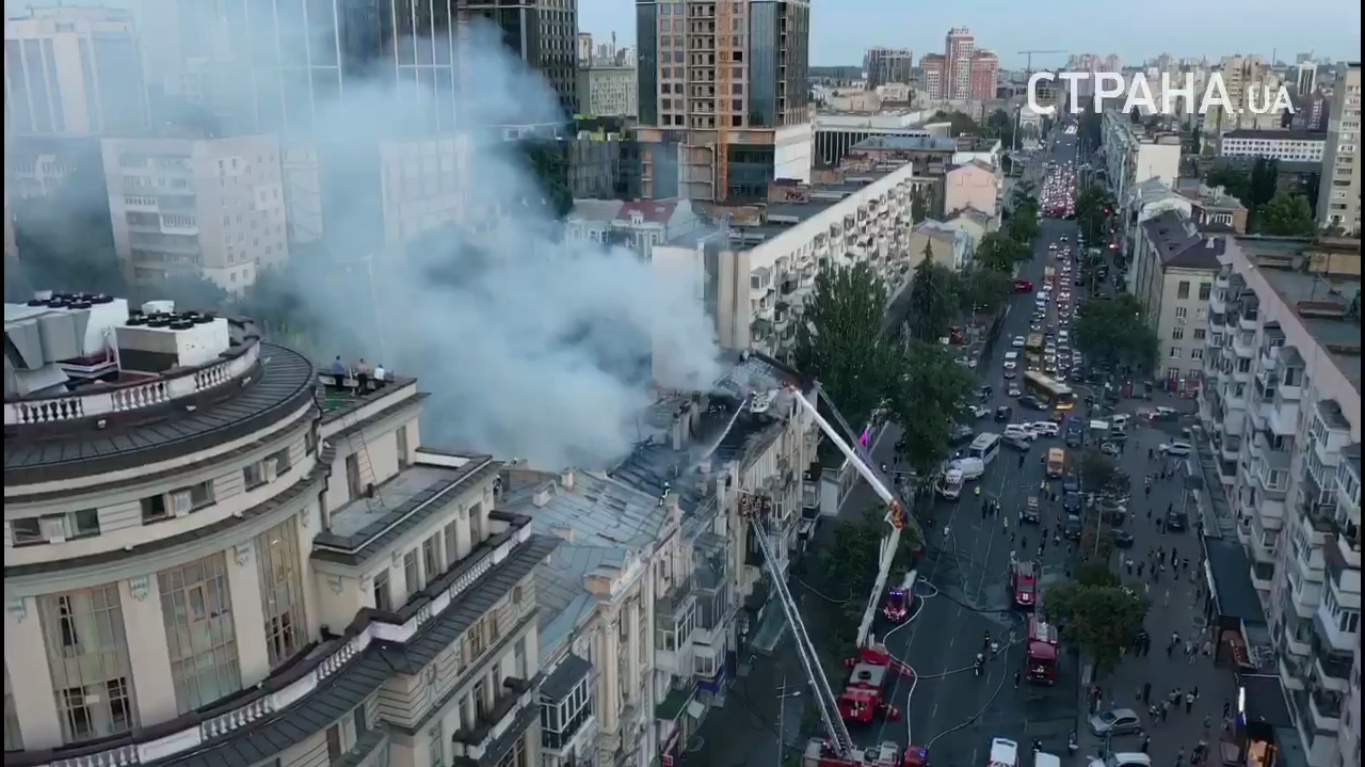 Возле горящего здания собрались люди.