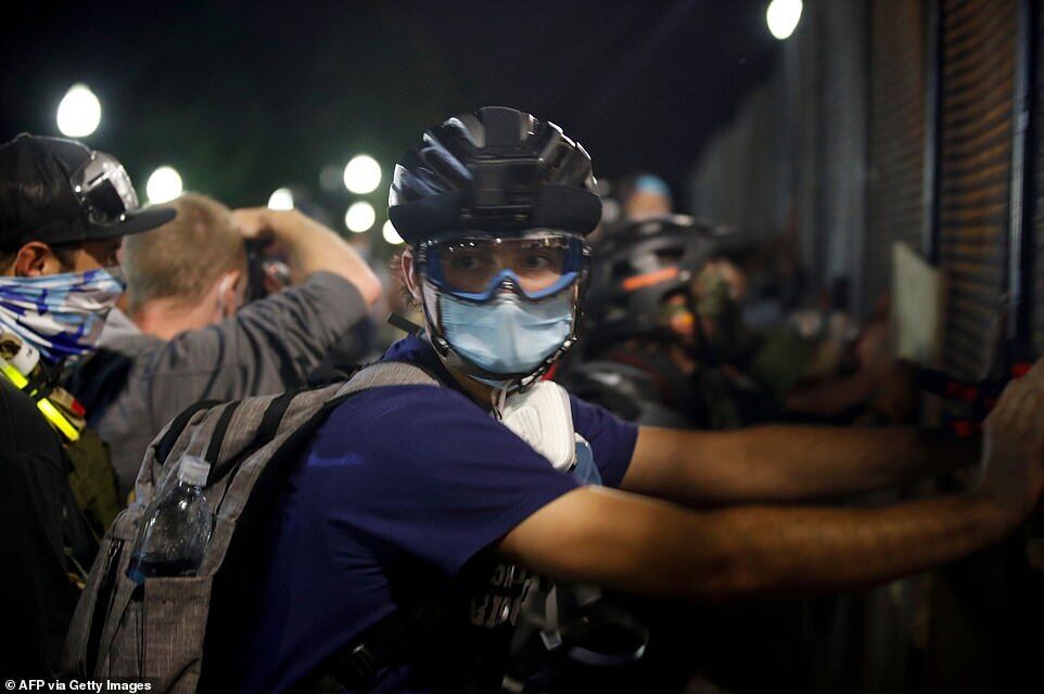 Протестующие собрались в шлемах и масках, а некоторые держали импровизированные щиты, готовясь к встрече с полицией