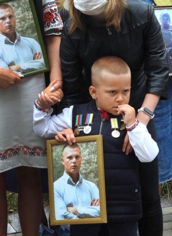 Мальчик держит в руках портрет погибшего на Донбассе отца-защитника, которого, возможно, и не помнит живым