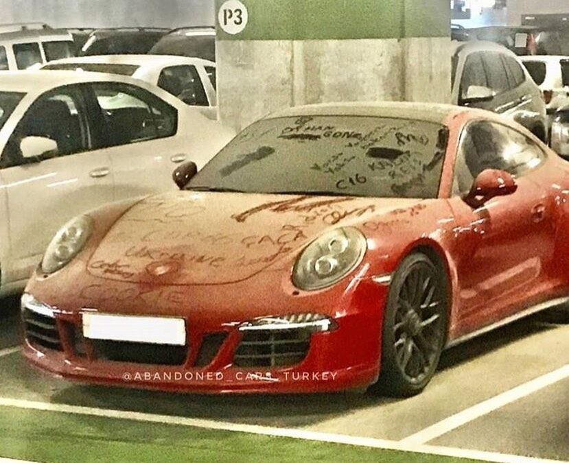 Пыльный кузов Porsche 911 полностью покрыт надписями.