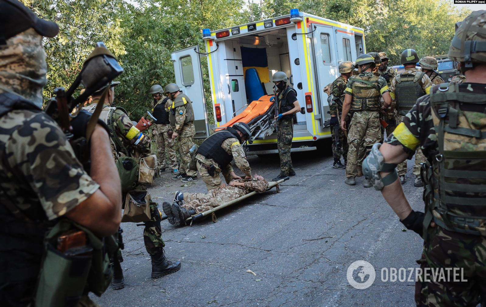 Украинские бойцы спасают товарища, раненого вблизи Иловайска 10 августа 2014 года