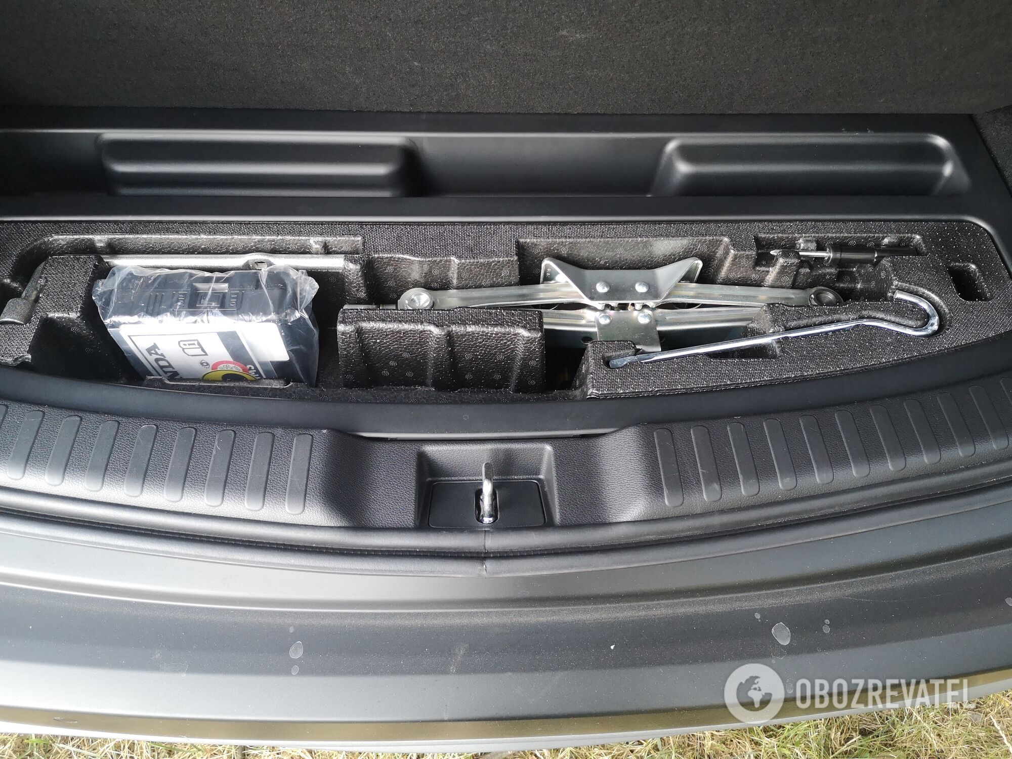 У CR-V Hybrid под полом багажника располагается литий-ионная батарея и органайзер с минимумом инстументов. Фото:
