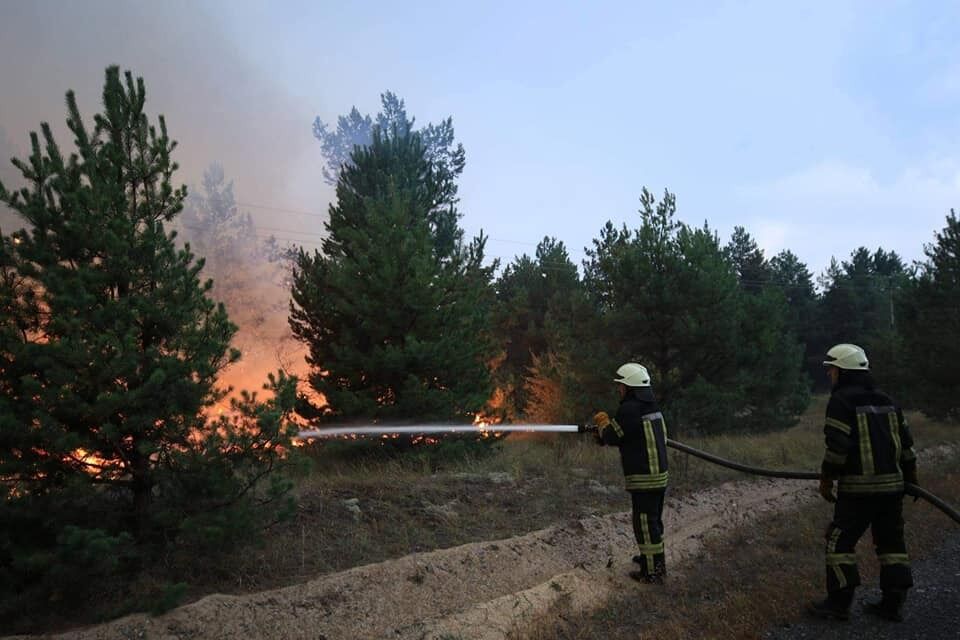 Сотрудники ГСЧС тушат пожар на полигоне в Киевской области.