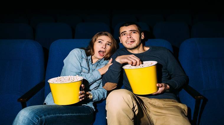 Пара смотрит фильм ужасов в кинотеатре