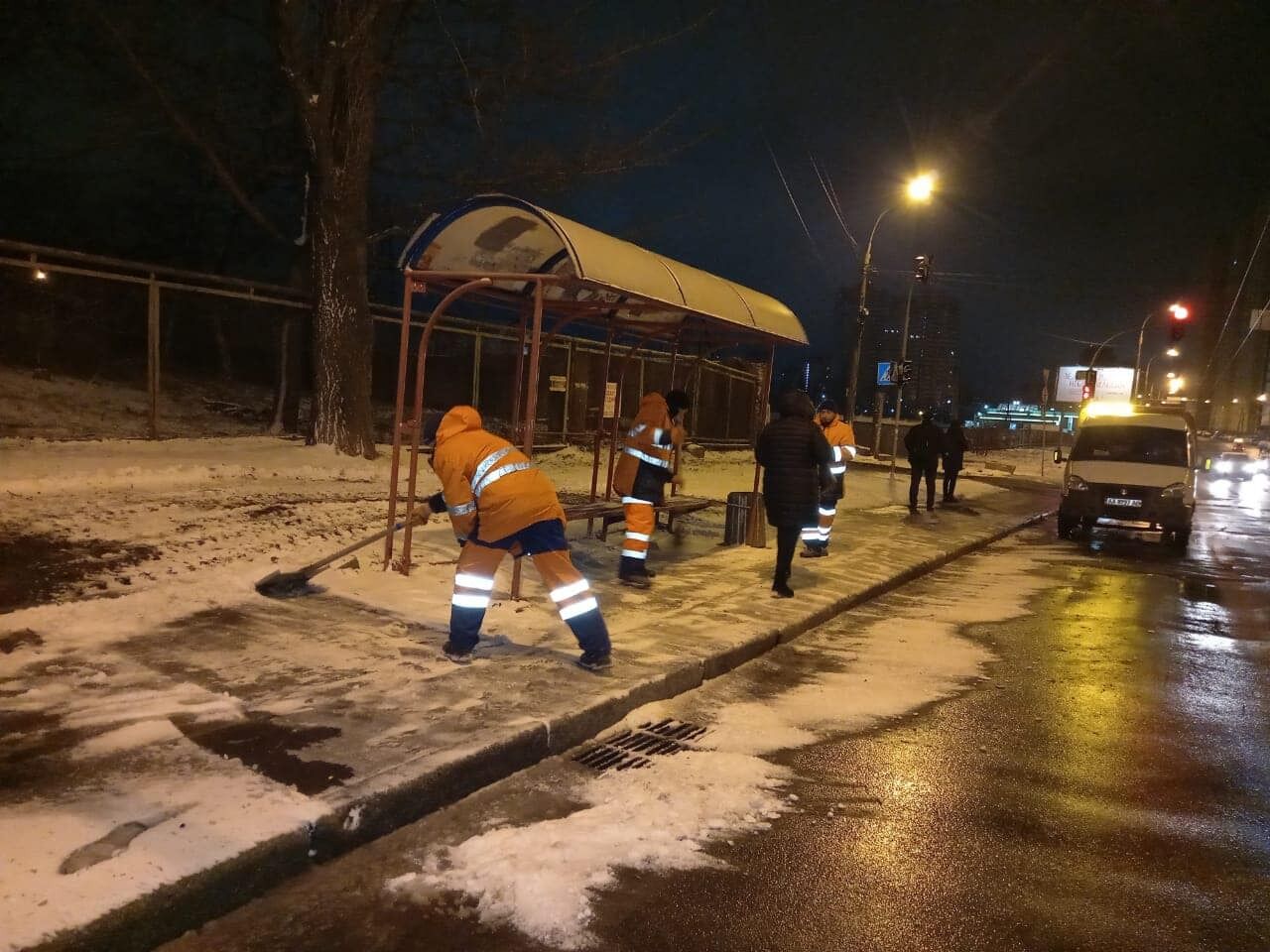 Комунальники чистять зупинки від снігу.