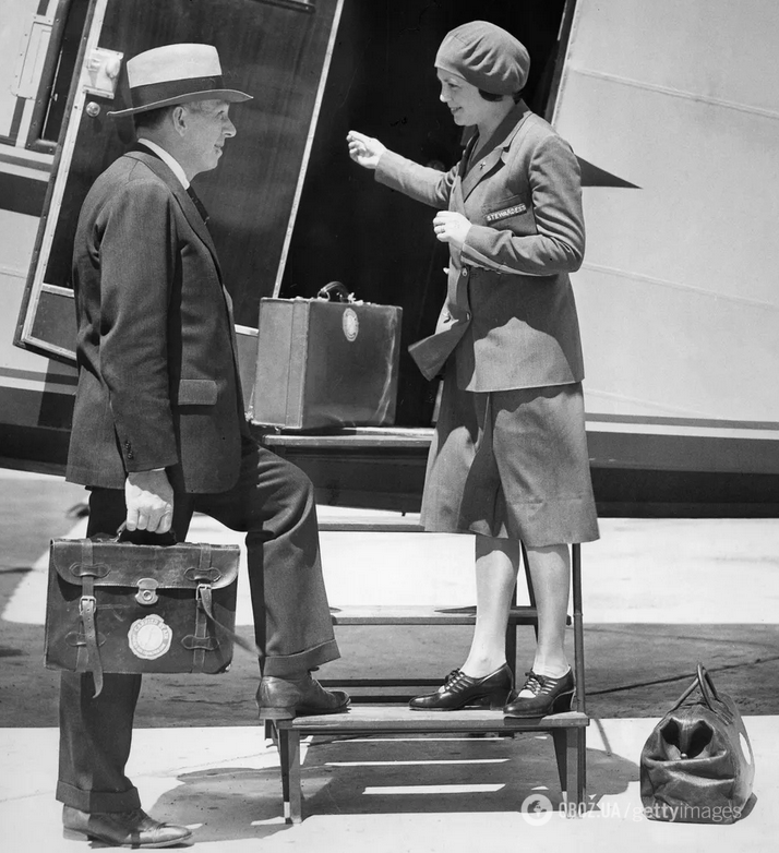25-річна медсестра Еллен Черч з Айови, яку часто вважають першою бортпровідницею в історії, зустрічає мандрівника біля дверей літака Boeing 80 A для Boeing Air Transport в 1930 році.