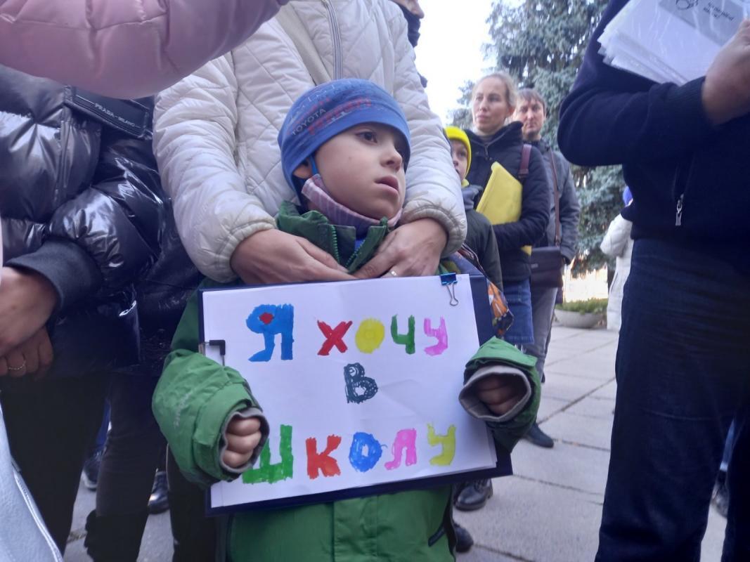 Мальчик на акции протеста с плакатом "Я хочу в школу"