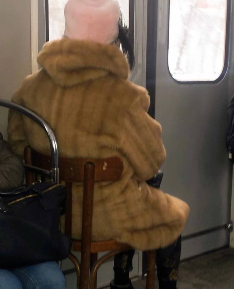 Женщина села на стул в метро.