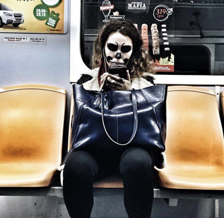 Девушка едет в метро с макияжем на Хэллоуин.