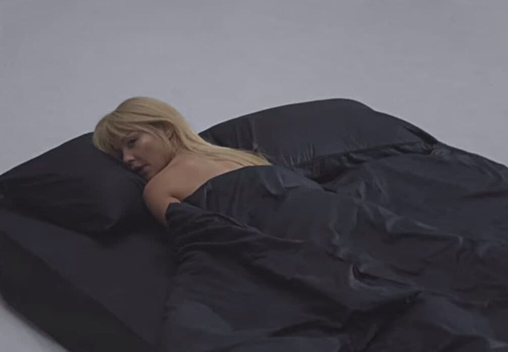 Кадр из клипа Тины Кароль - певица в постели.