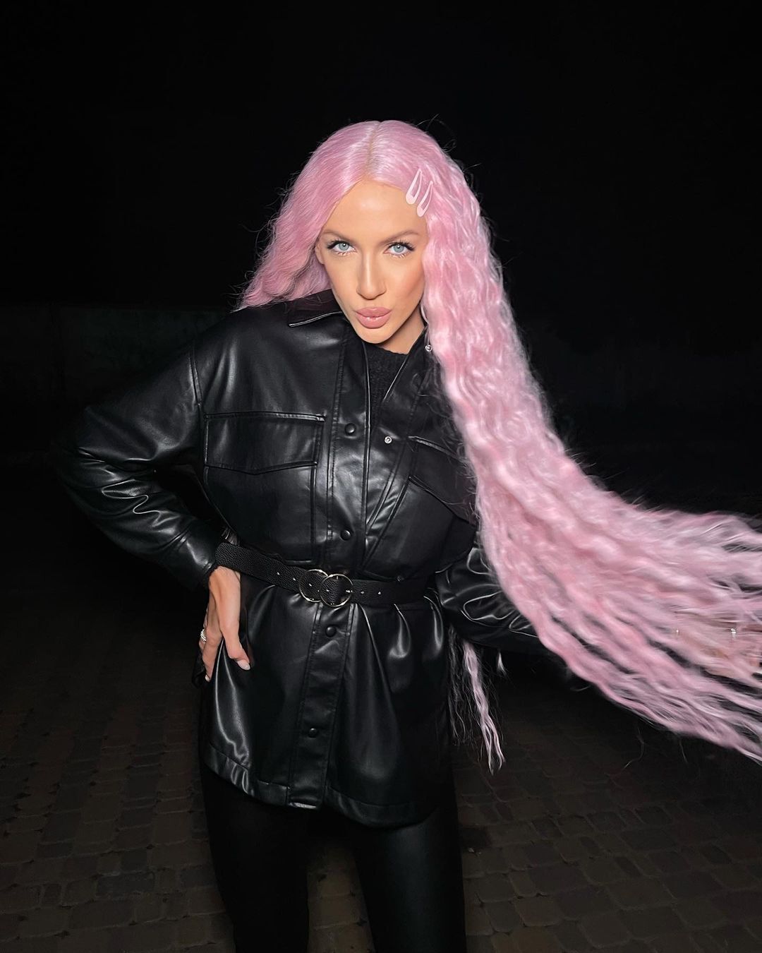 Леся Никитюк позирует на камеру с розовыми волосами.