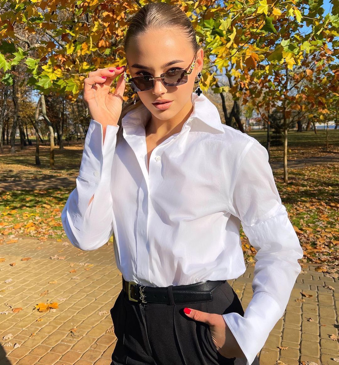 Дарья Белодед в белой блузке и очках.