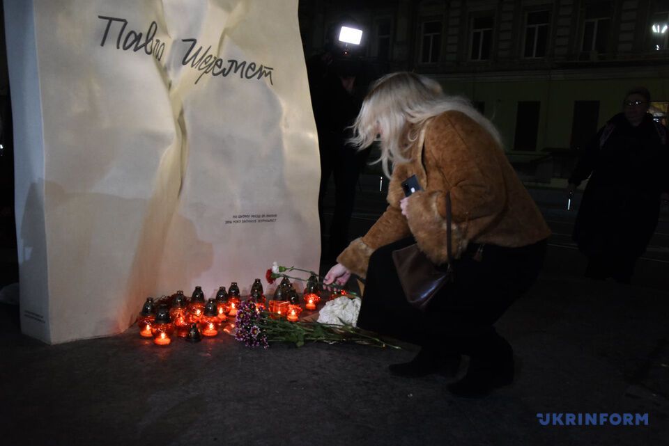 Почитатели журналиста несут цветы и свечи.