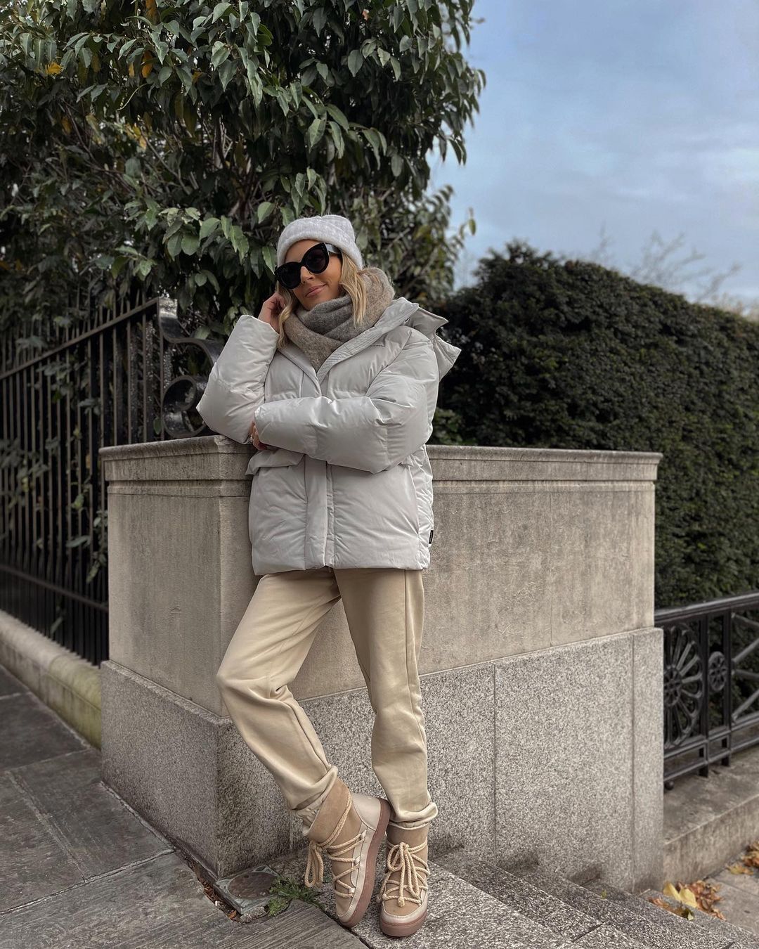 Лаура Уилс одевает бежевые джоггеры и белую дутую куртку.