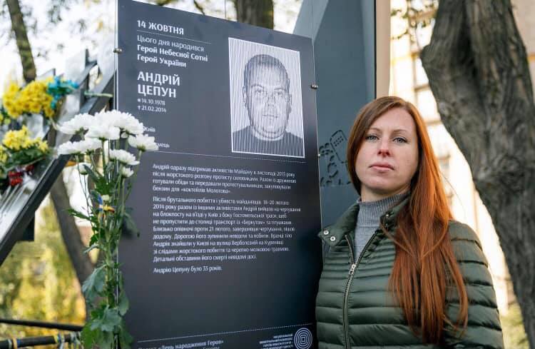 Юлія Цепун біля меморіальної таблички загиблому чоловікові