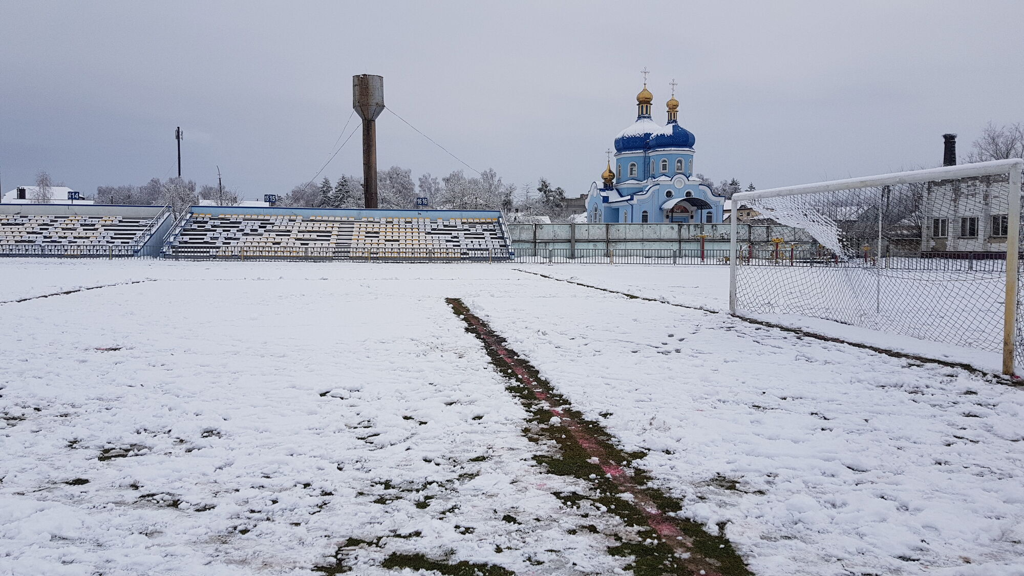 Снег на футбольном поле.