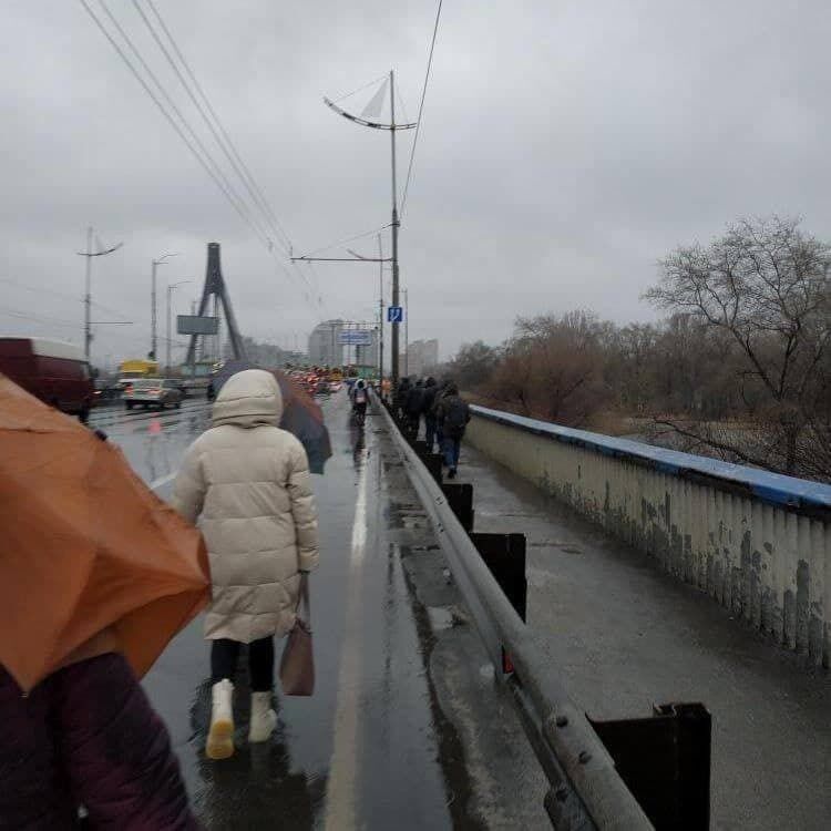 Люди шли пешком из-за того, что остановились троллейбусы на Северном мосту.