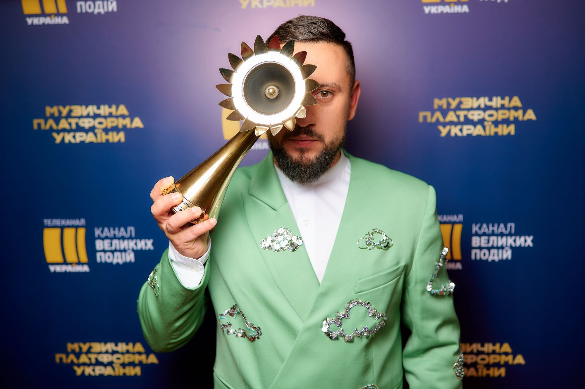 MONATIK в зеленом костюме.