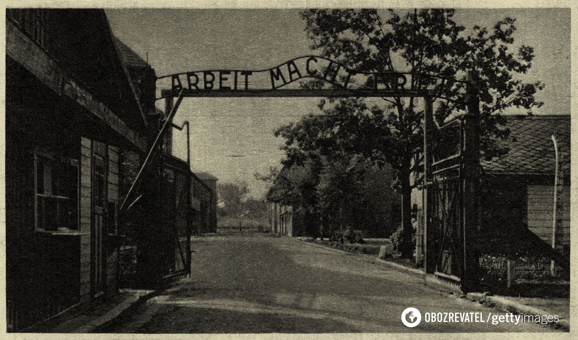 Листівка концтабору Освенцим I, краєвид на металеву таблицю з надписом "Arbeit Mach Frei" – "Робота робить вас вільними"