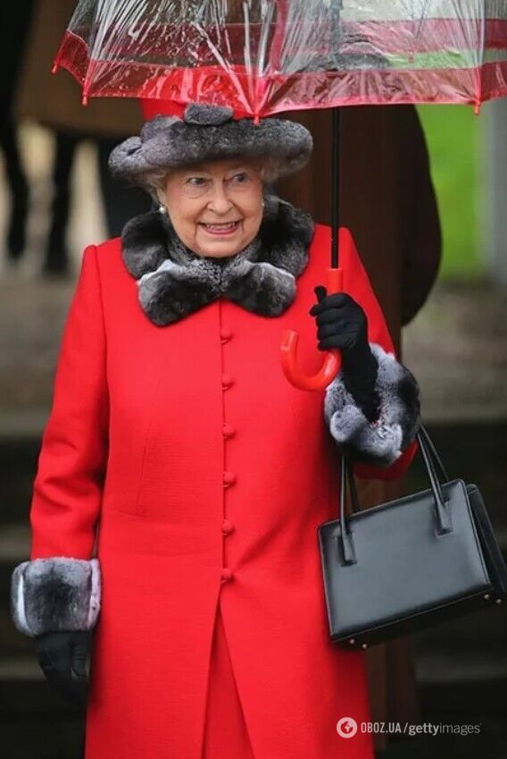 Елизавета II носит зонт в соответствии с образом.