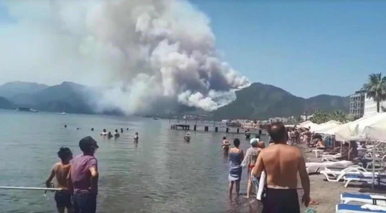 Люди с пляжа наблюдают за пожаром