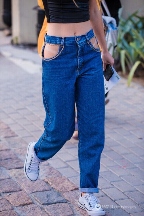Синие джинсы с вырезами.