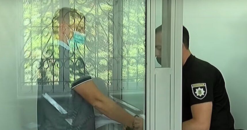 С подозреваемого снимают наручники во время суда.
