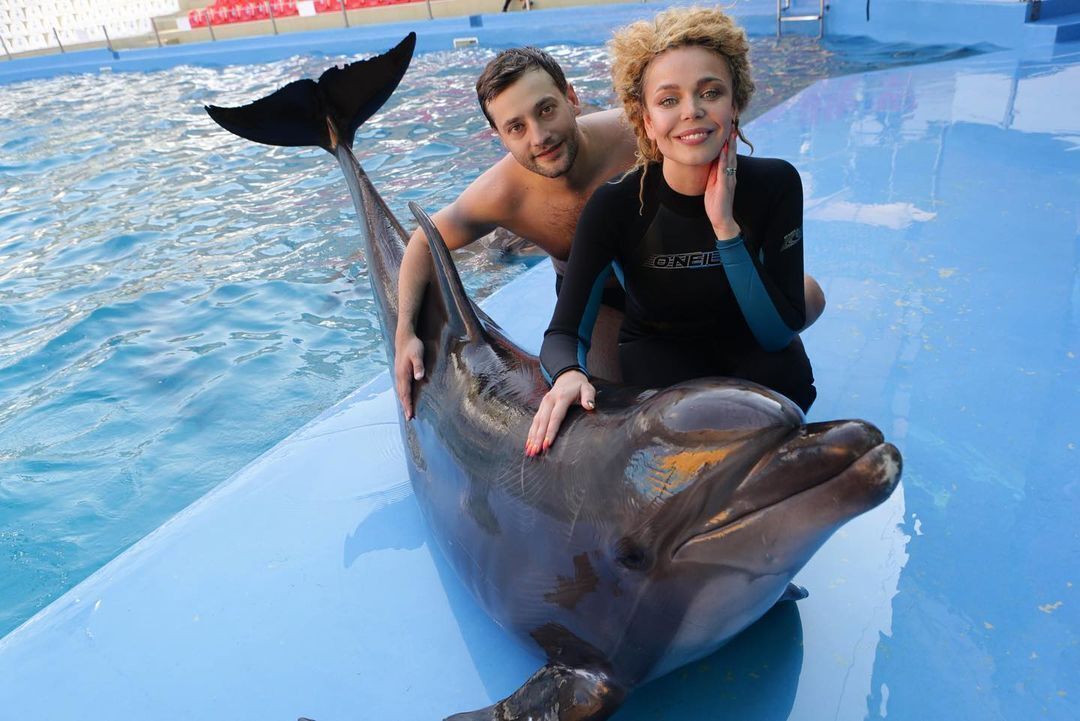 Роман и Алина позирует с дельфином.