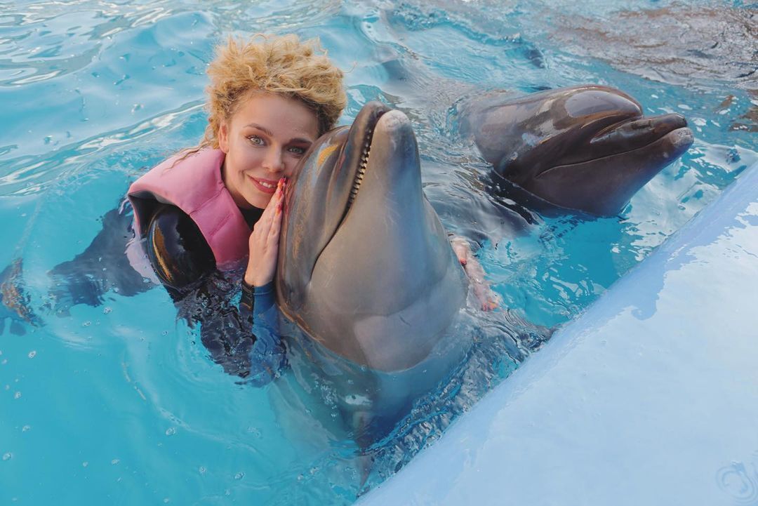 Алина Гросу обнимается с дельфином.