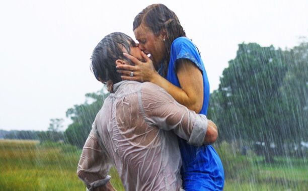 Влюбленная пара целуется под дождем.