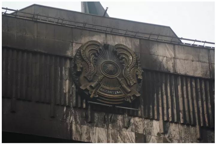 Обгоревший герб на здании в Алматы