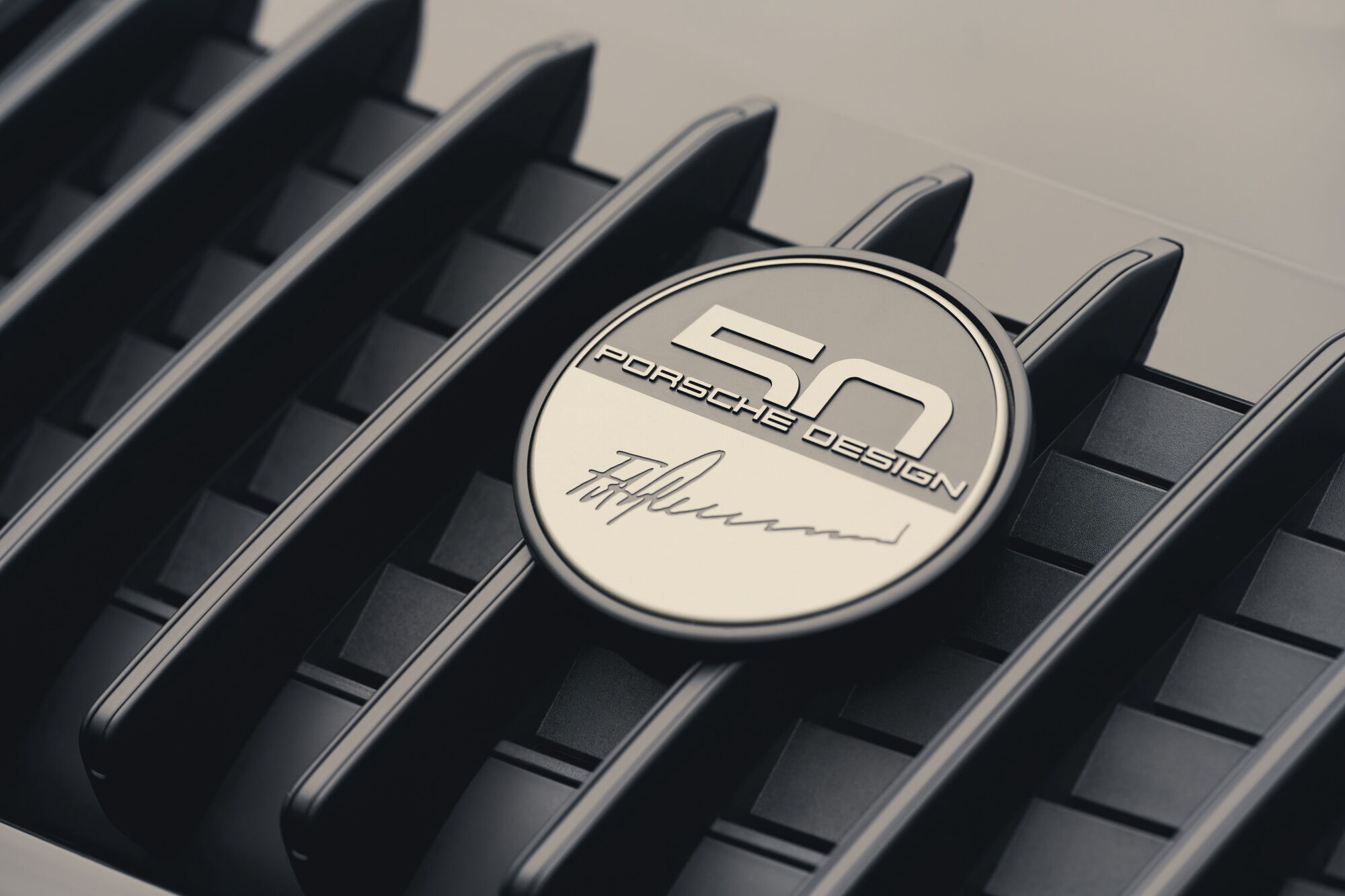 Грати кришки двигуна прикрасив значок "50 років Porsche Design" з факсимільним підписом Фердинанда Олександра Порше