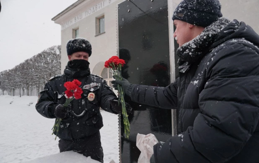 Родичі загиблих передають квіти для покладання варті Путіна.