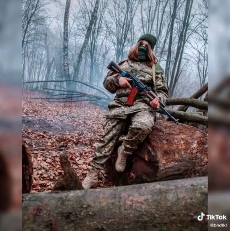 Жінки-військові позують зі зброєю.