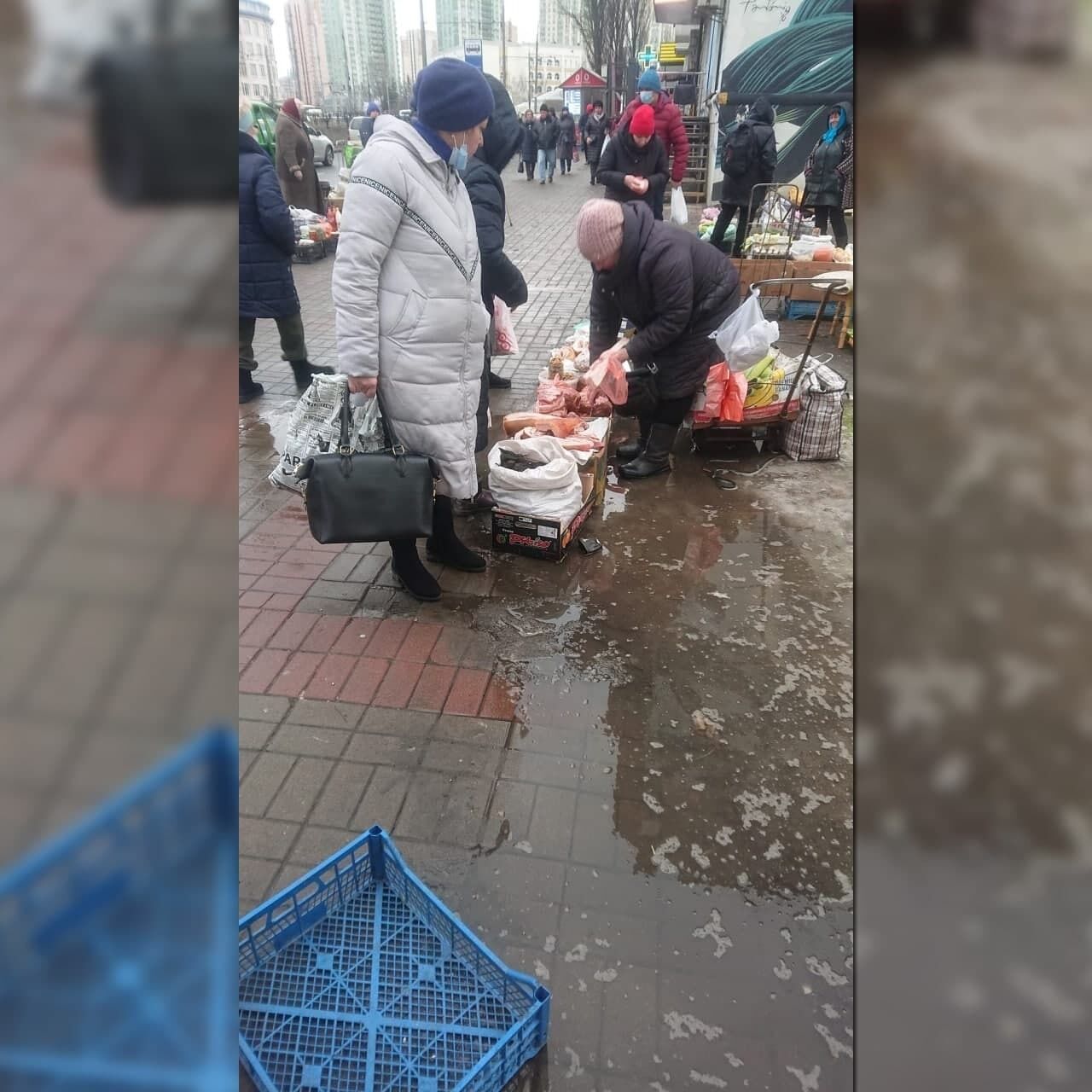 Жінка поставила ящики з товаром посеред калюжі.