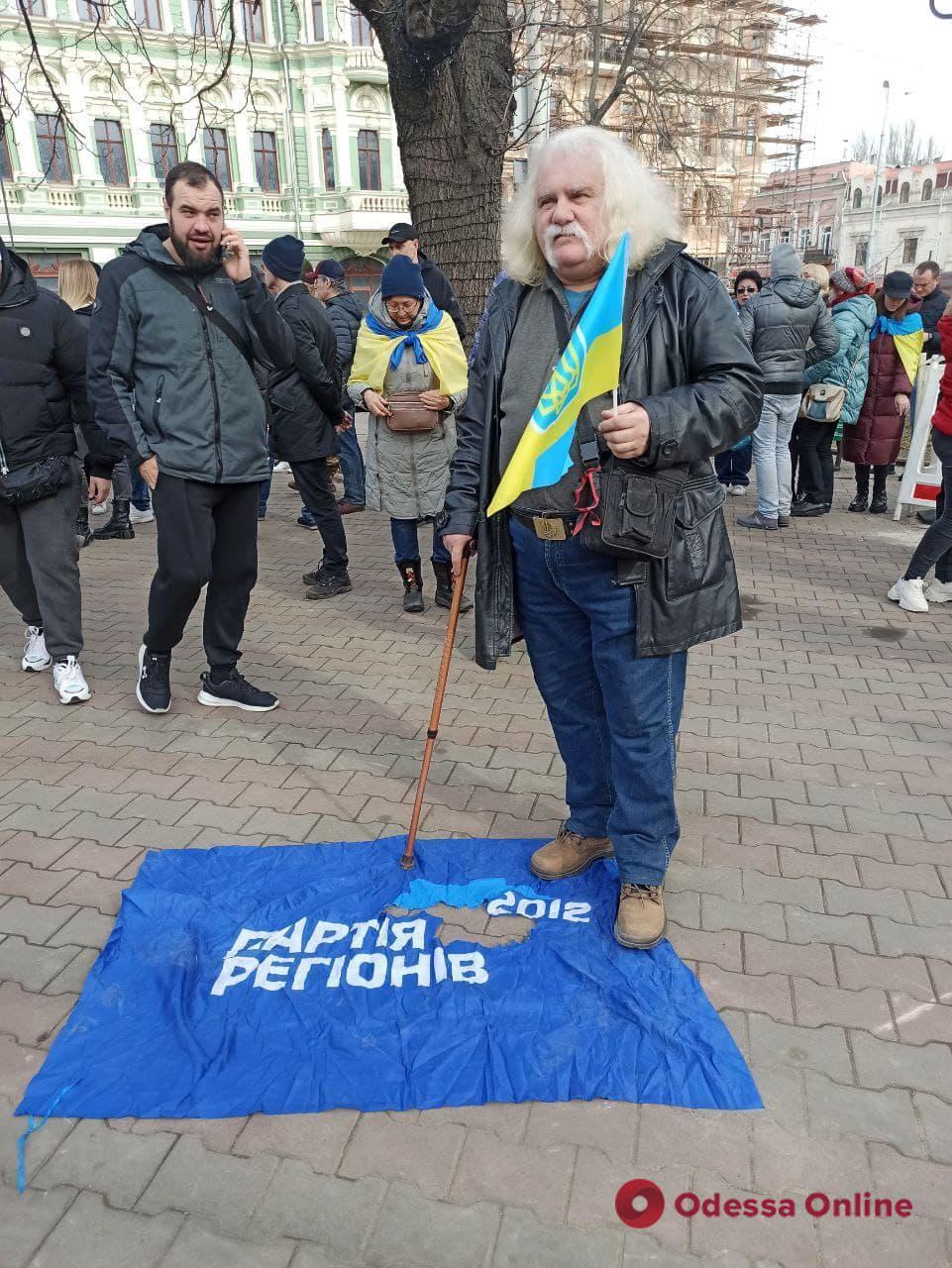 Участник марша положил на тротуар флаг "Партии Регионов"