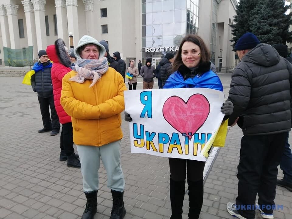 Люди пришли на митинг с плакатами и украинскими флагами