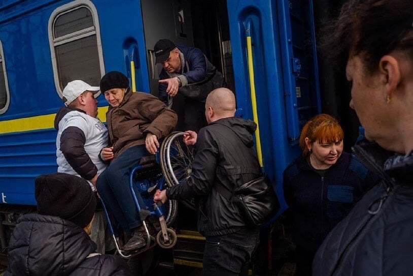 Украинцы помогают бабушке на коляске покинуть поезд