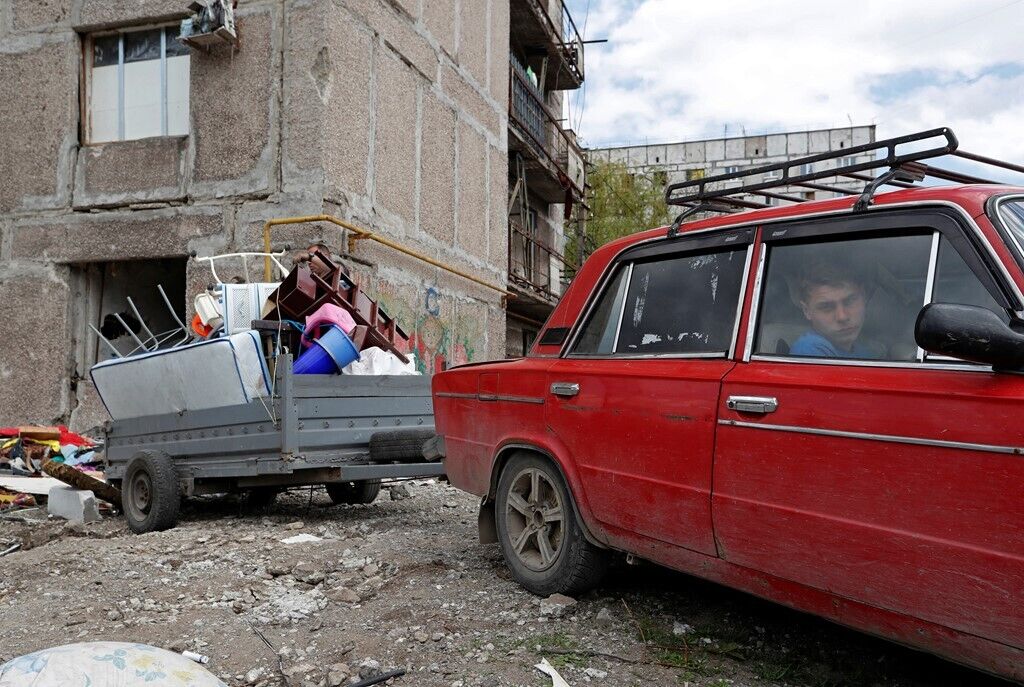 Жители пытаются перенести вещи из разрушенных домов