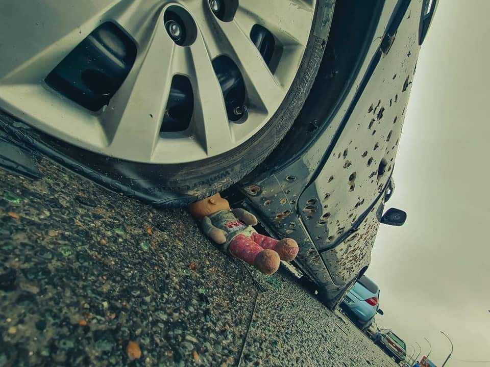 Дитяча іграшка біля розстріляної машини