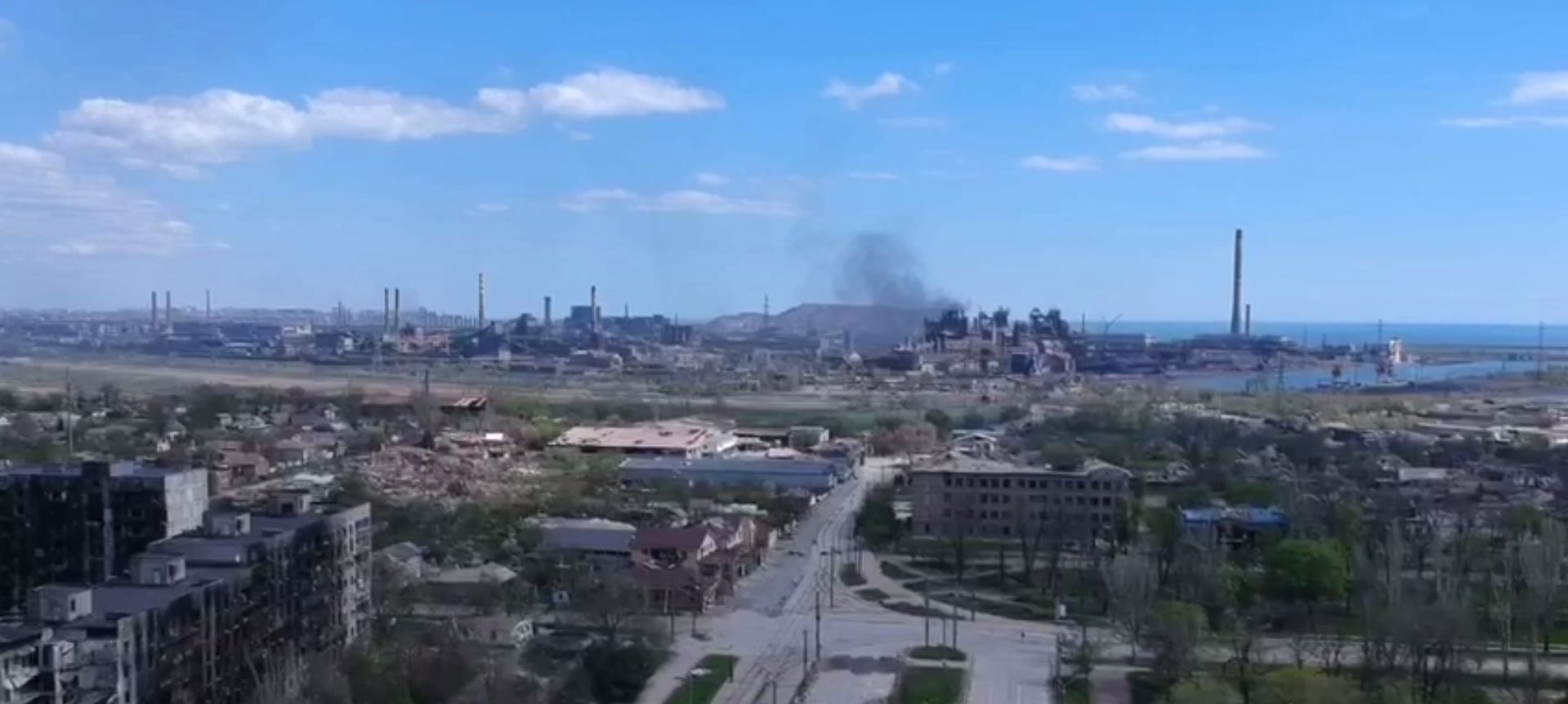 Зруйновані обгорілі будинки та дим над комбінатом "Азовсталь"