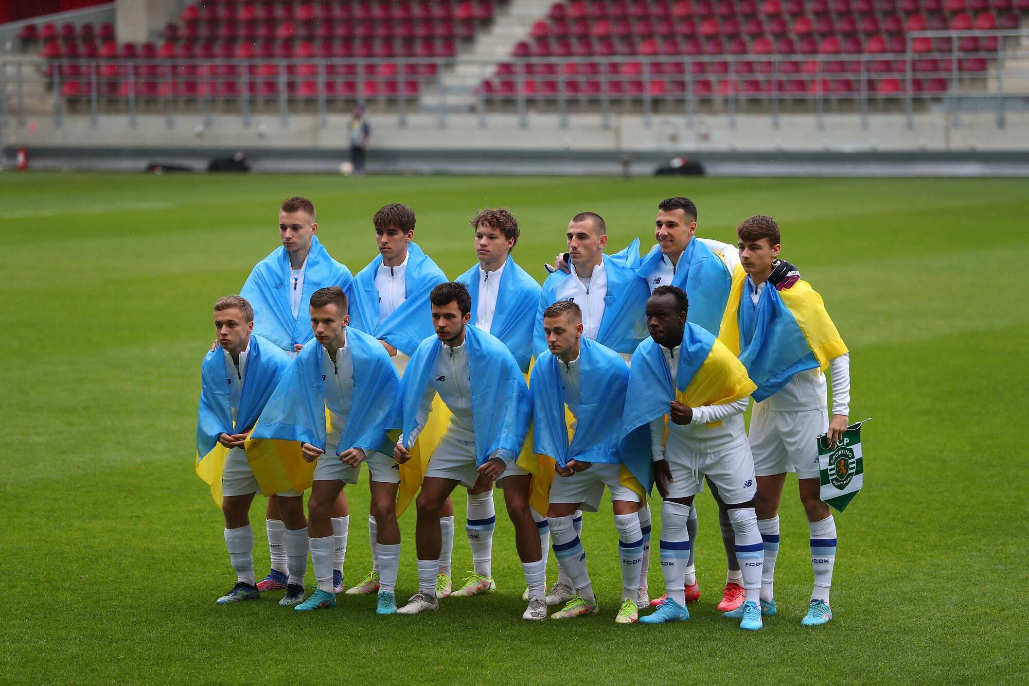 Футболісти юнацької команди "Динамо" із українськими прапорами.