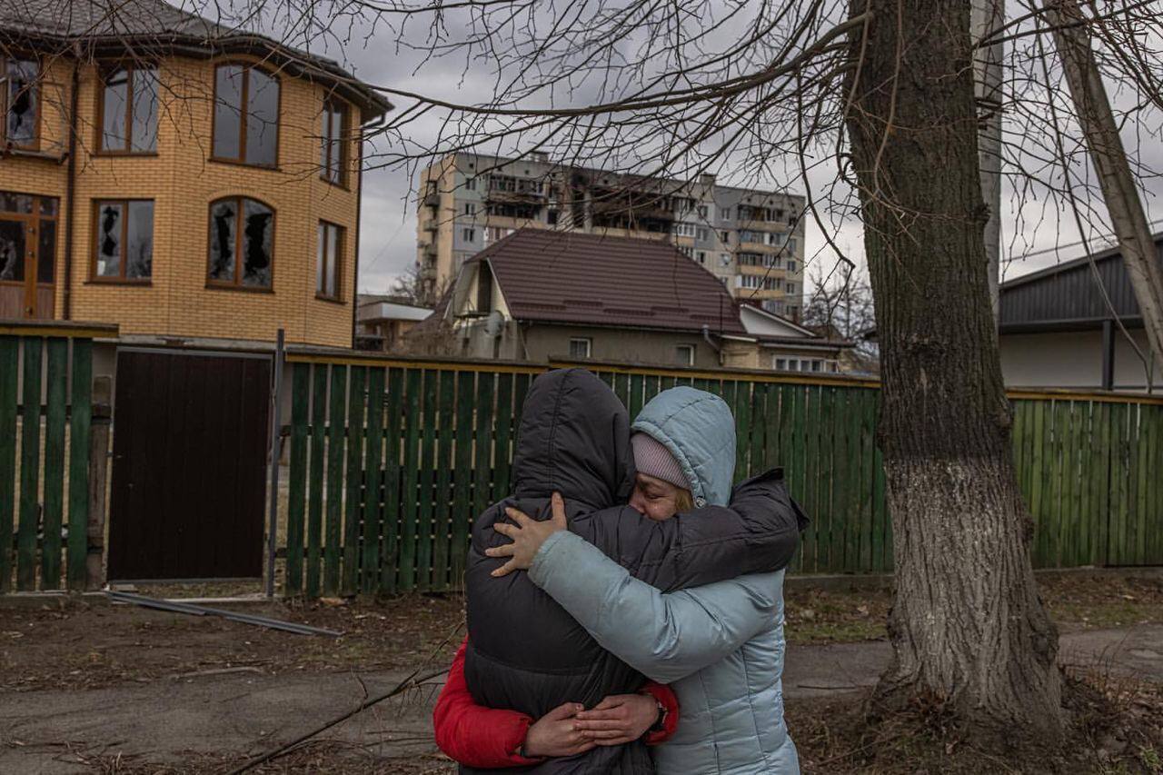 Люди на фоне разрушенных домов