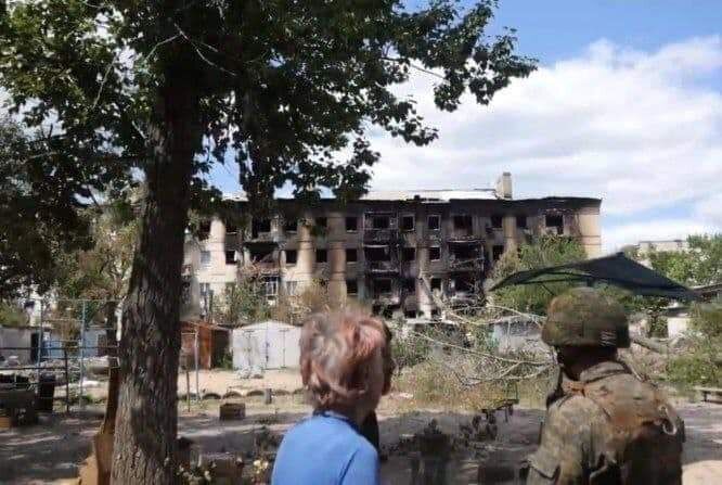 Цивільний і військовий дивляться на зруйнований будинок