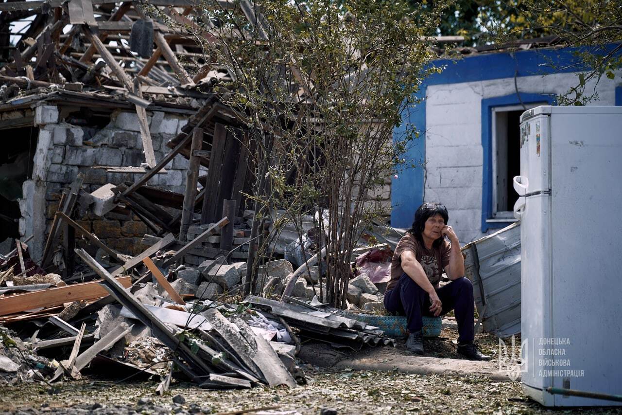 Местная жительница на руинах своего дома.