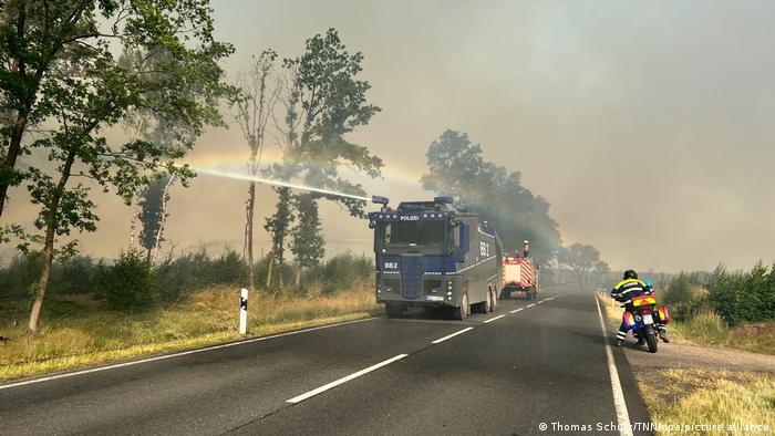 Полицейский грузовик с водометом тушит пожар в Троенбритцене, близ Берлина